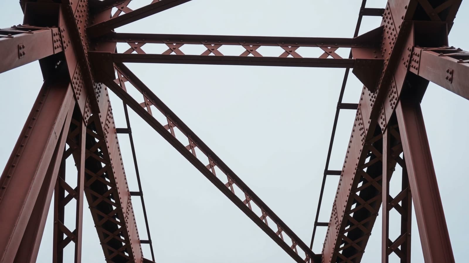 Red-painted girders rising against a grey sky